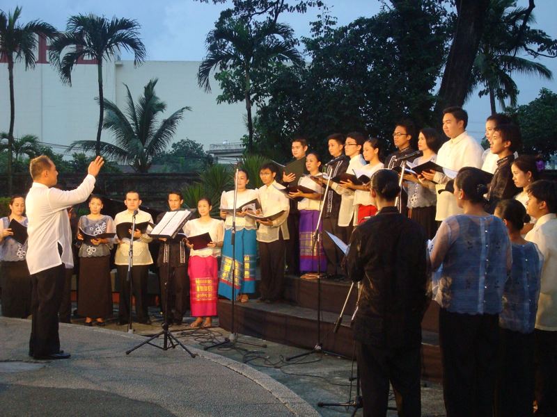 A conductor leading a choir outdoors