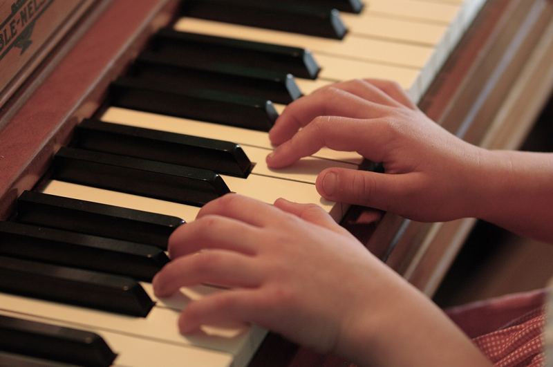 Hands practising on a piano